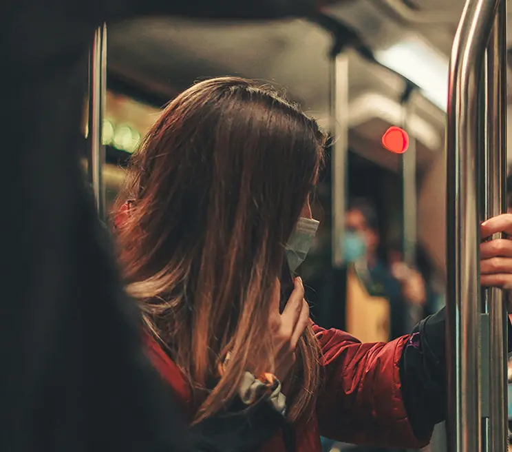 Donna su un vagone della metropolitana di Roma, che guarda fuori mentre si tiene al corrimano