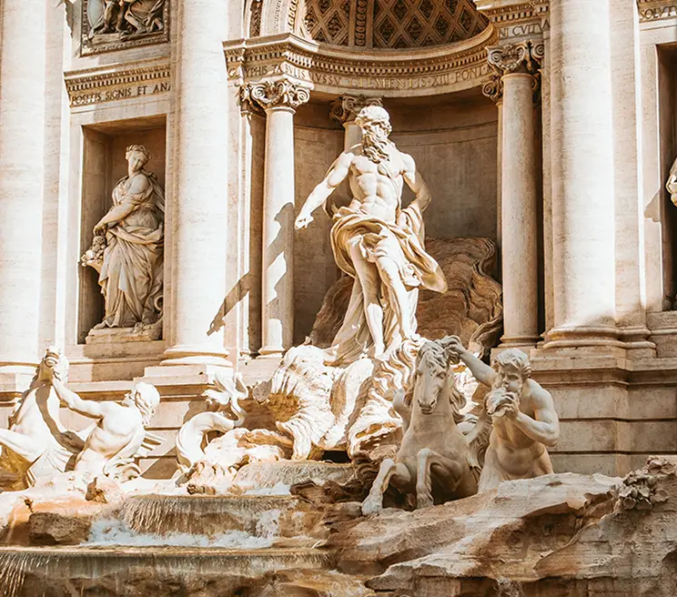 Fontana di Trevi illuminata dal sole, circondata da dettagli architettonici storici.