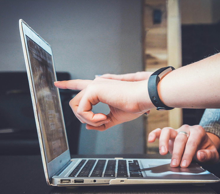 Persona che indica con il dito lo schermo di un laptop, a rappresentare i contenuti del Portale Istituzionale di Roma Capitale